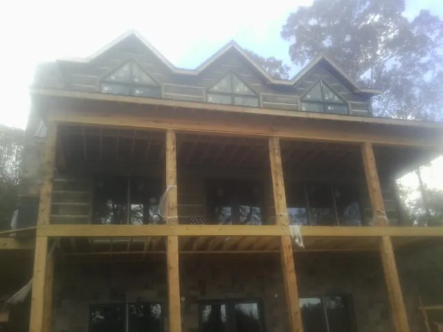 Dormers and porch framing on a large log home under construction — Roof Coating work by our crew in Gardnerville