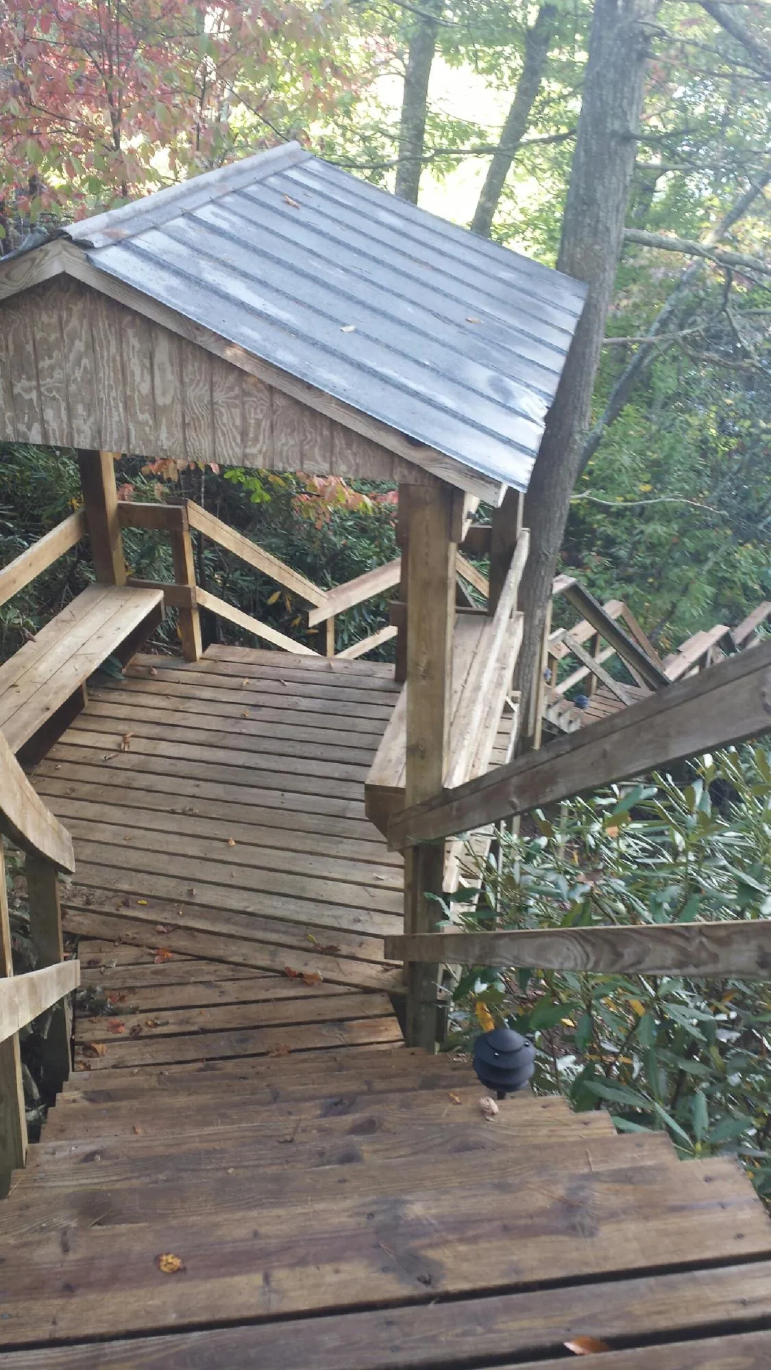 Metal roofed shelter over wooden steps on a wooded walkway — Skylight Repair & Installation work by our crew in Gardnerville